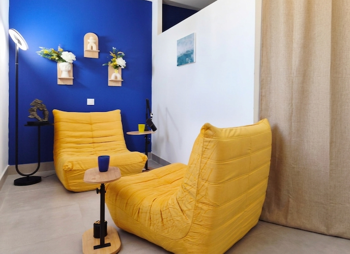 Cabinet de psychothérapie d'Émilie Giacobi, Psychothérapie Gestalt à Lunel Viel, avec des fauteuils jaunes confortables dans une pièce joliment décorée en bleu